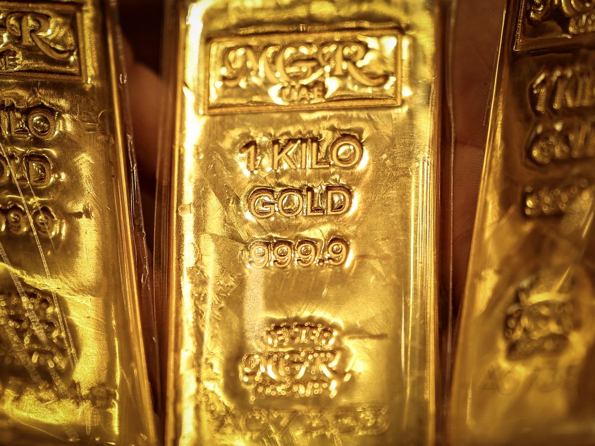 An Emirati gold dealer holds bars of gold in a shop in the Dubai Gold Souk on April 13, 2025.