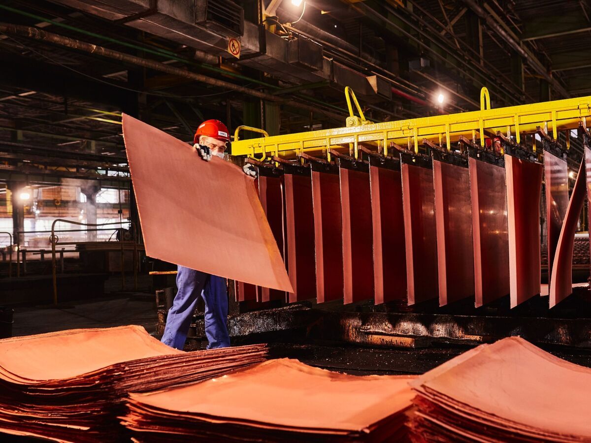 A worker handles newly formed copper cathode sheets in a warehouse at the KGHM Polska Miedz SA copper smelting plant in Glogow, Poland, on Tuesday, March 9, 2021.