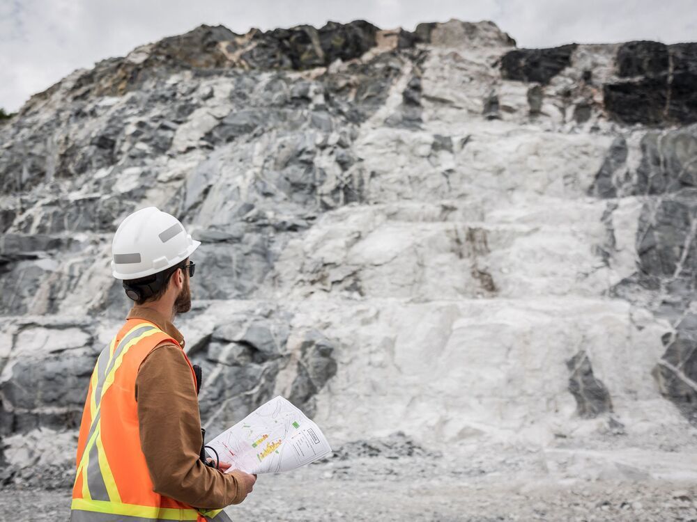 This handout picture provided by Sayona on March 29, 2023 shows an employee of Sayona Quebec in front of a lithium deposit at the company's North American Lithium Complex in La Corne, central Quebec, on July 20, 2022.