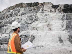 This handout picture provided by Sayona on March 29, 2023 shows an employee of Sayona Quebec in front of a lithium deposit at the company's North American Lithium Complex in La Corne, central Quebec, on July 20, 2022.