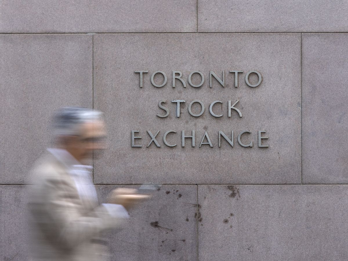 A pedestrian walks past Toronto Stock Exchange signage in Toronto’s Financial District, Tuesday July 29, 2025.