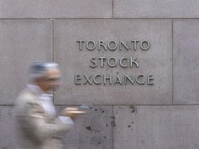 A pedestrian walks past Toronto Stock Exchange signage in Toronto’s Financial District, Tuesday July 29, 2025.