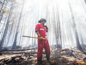In this May 30, 2023, image courtesy of the Nova Scotia Government in Canada, Halifax Regional Fire and Emergency firefighter Zach Rafuse from Port Williams works to put out fires in the Tantallon area.