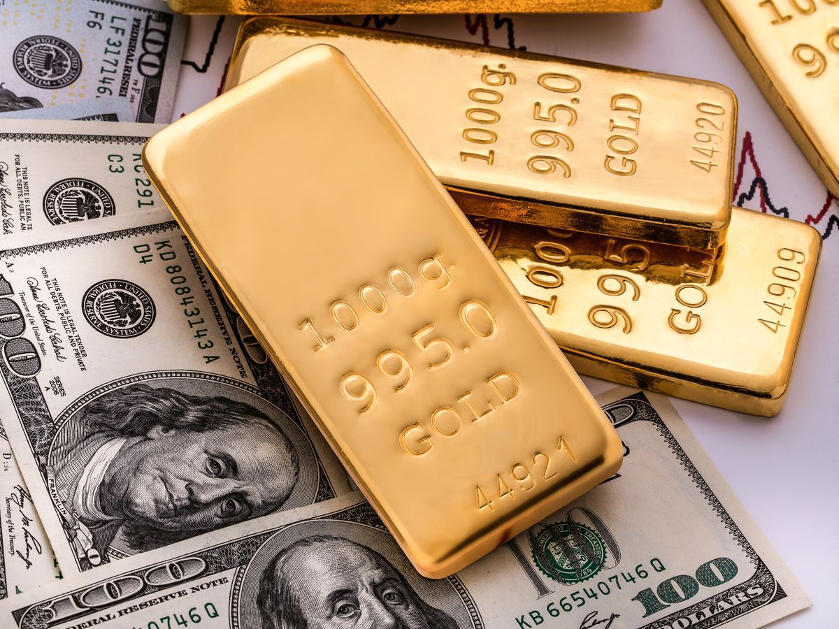 Gold bullions on hundred dollars banknotes and chart background