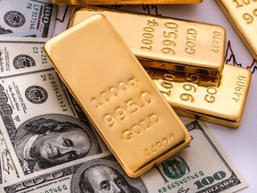 Gold bullions on hundred dollars banknotes and chart background