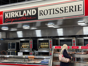 Customer selecting rotisserie chicken, Costco, Florida.