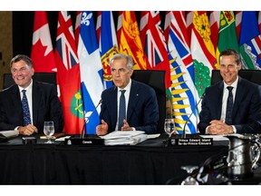 Prime Minister Mark Carney, center, and Canada-US Trade Minister Dominic LeBlanc, left, speak to Canada's provincial leaders at a meeting last month.