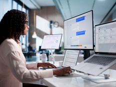 Young African American Woman Working On Laptop And Desktop