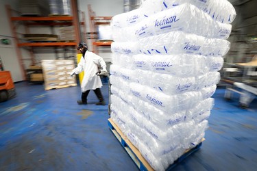 An employee moves newly bagged ice onto pallets at the Iceman facility in Concord, Ont.