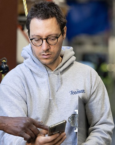 Jake Silva wears an Iceman hoodie while discussing a shipment with a driver.