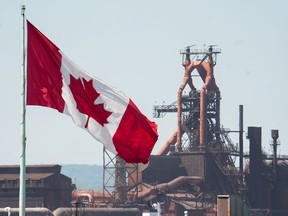 A Canadian flag flies above the steel mills in Hamilton, Ont. A new federal program will subsidize shipping Canadian steel within the country.