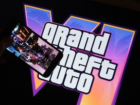 This illustration photo created in Los Angeles, December 4, 2023, shows Rockstar Games' Grand Theft Auto VI trailer played on a screen in front of the game title.