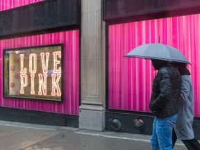 A couple walk past the Victoria’s Secret building on Stanley Street in Montreal on March 28, 2021.