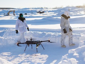 Canadian sailors walk by a drone as a team from the Canadian Navy test thermal imaging drone capabilities in Arctic environments, during Operation Nanook, the Canadian Armed Forces' annual Arctic training and sovereignty operation, in Inuvik, Northwest Territories, Canada, February 27, 2025.