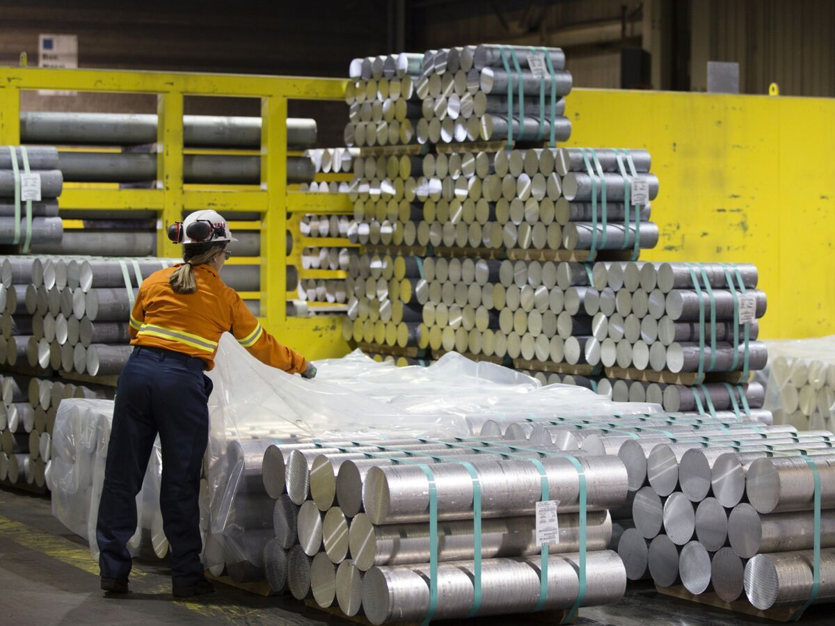 An employee covers a stack of aluminum billets with plastic at the Rio Tinto Plc DC45 Casting Centre at Complexe Jonquiere in Saguenay, Quebec, Canada, on Thursday, June 21, 2018