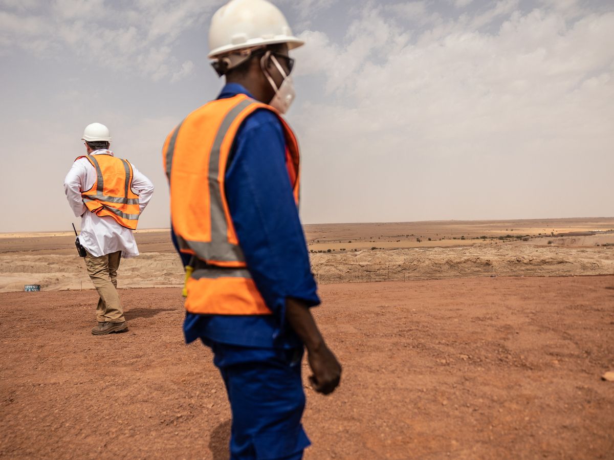 Mine workers walk on the residual dump at the Cominak mine near Arlit on March 8, 2023.