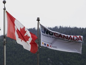 Flags fly outside the LNG Canada office in Kitimat, British Columbia. Carney travels to the province today to mark an “historic” investment in Canada’s energy sector.