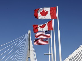 Flags of Canada and United States fly across the international border on the Gordie Howe International Bridge that connects Windsor, Ont., and Detroit, Michigan.