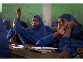 Twelve-year-old Layla, displaced from her pastoral village of Caanoole due to severe drought, raises her hand during a lesson at in Kismayo, Somalia.