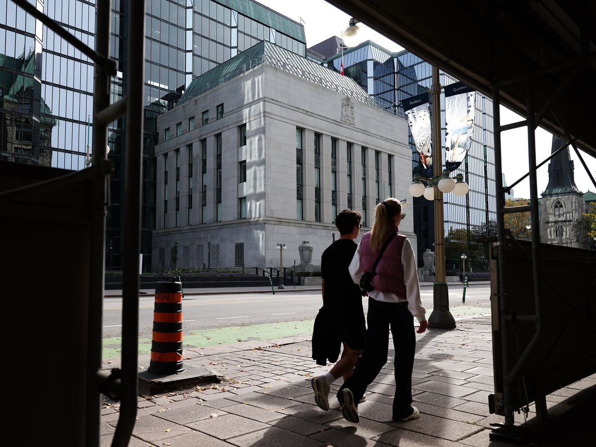 Pedestrians walk on the sidewalk across from the Bank of Canada building in Ottawa on Wednesday, Sept. 30, 2026.