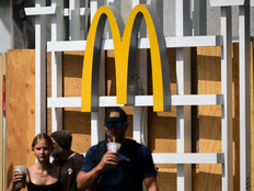 The McDonalds logo is displayed as people carry McCafe coffee beverages from a McDonalds fast food restaurant undergoing renovations in Santa Monica, California on July 28, 2026.