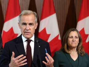 Canada's Prime Minister Mark Carney (C) speaks during a news conference, alongside President of the King's Privy Council for Canada Dominic LeBlanc (L) and Minister of Transport and Internal Trade Chrystia Freeland (R), during a news conference on Parliament Hill in Ottawa on June 6, 2025.