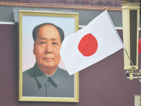 The Japanese flag flies near the portrait of late Chinese communist leader Mao Zedong in Beijing's Tiananmen Square on October 25, 2018