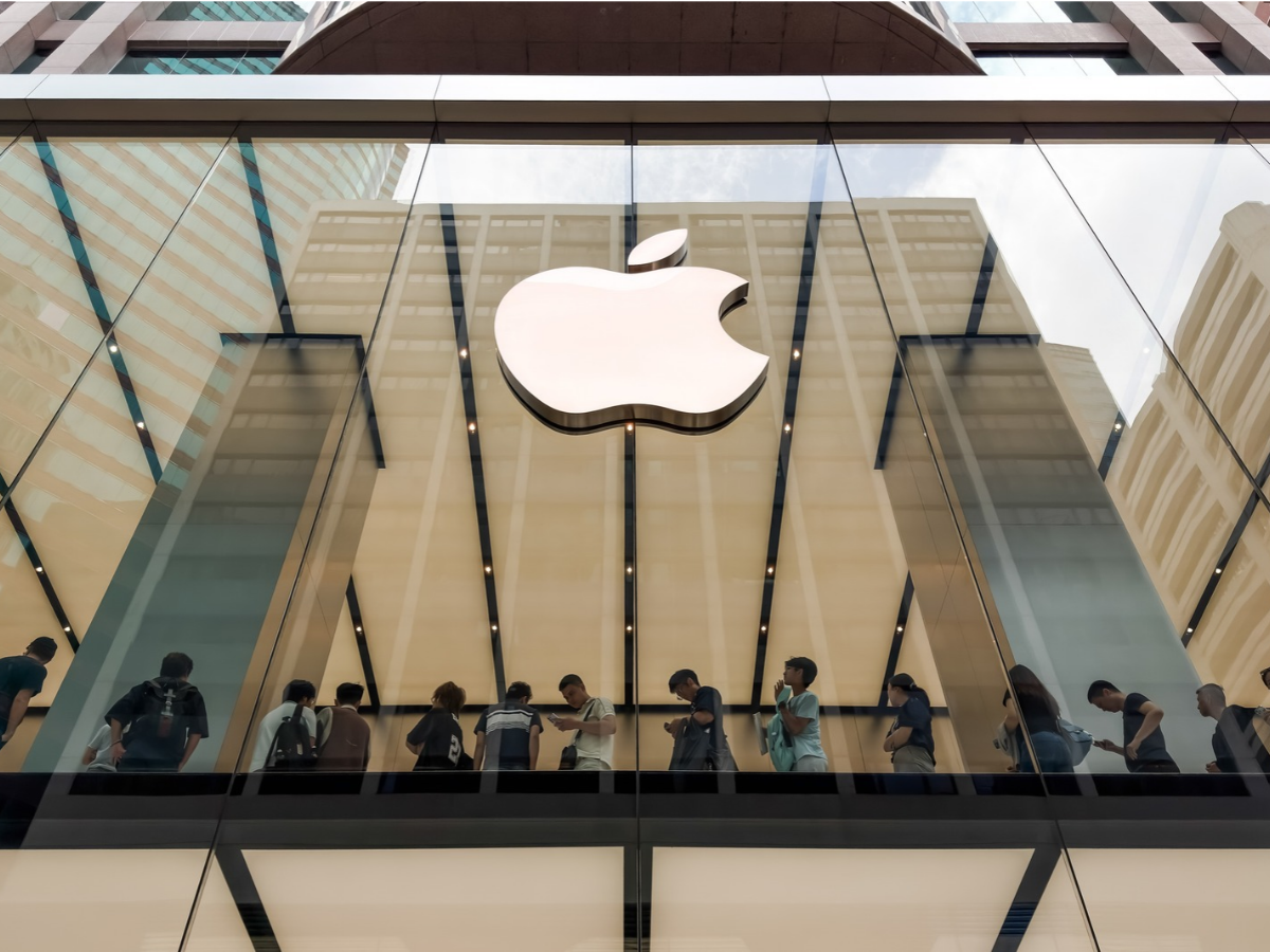 Customers queue inside an Apple store beneath an illuminated Apple logo to collect preordered products, mainly iPhone 18 Pro smartphones, on October 17, 2026 in Hong Kong, China. Apple (NASDAQ: AAPL) has opened preorders for its first foldable smartphone, iPhone Duo, ahead of its October 23 release, with strong initial demand pushing online delivery estimates into January 2027.
