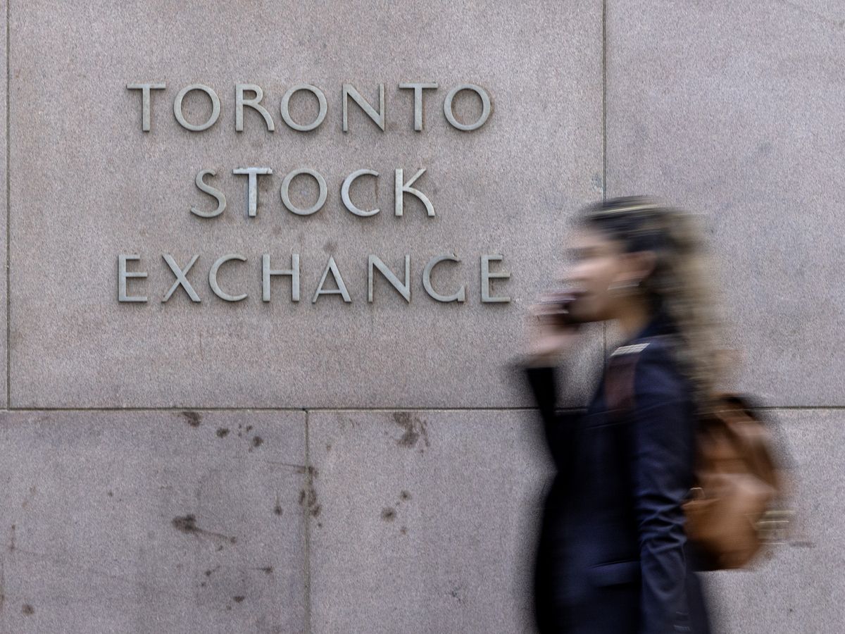 A pedestrian walks past Toronto Stock Exchange signage in Toronto’s Financial District on July 29, 2025.