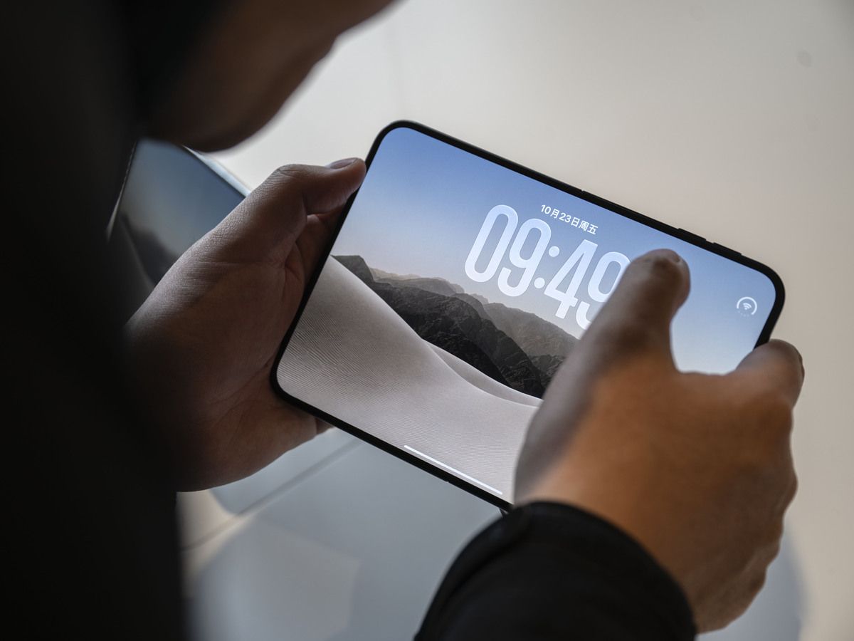 A customer looks at the new Apple Duo foldable smartphone during the first day of sales at the Apple flagship store on October 23, 2026 in Beijing, China.