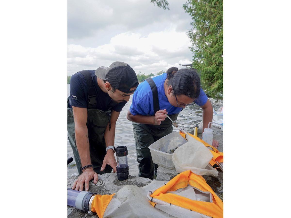 A Drinking Water Intern works with a Water First trainer during a field lesson.