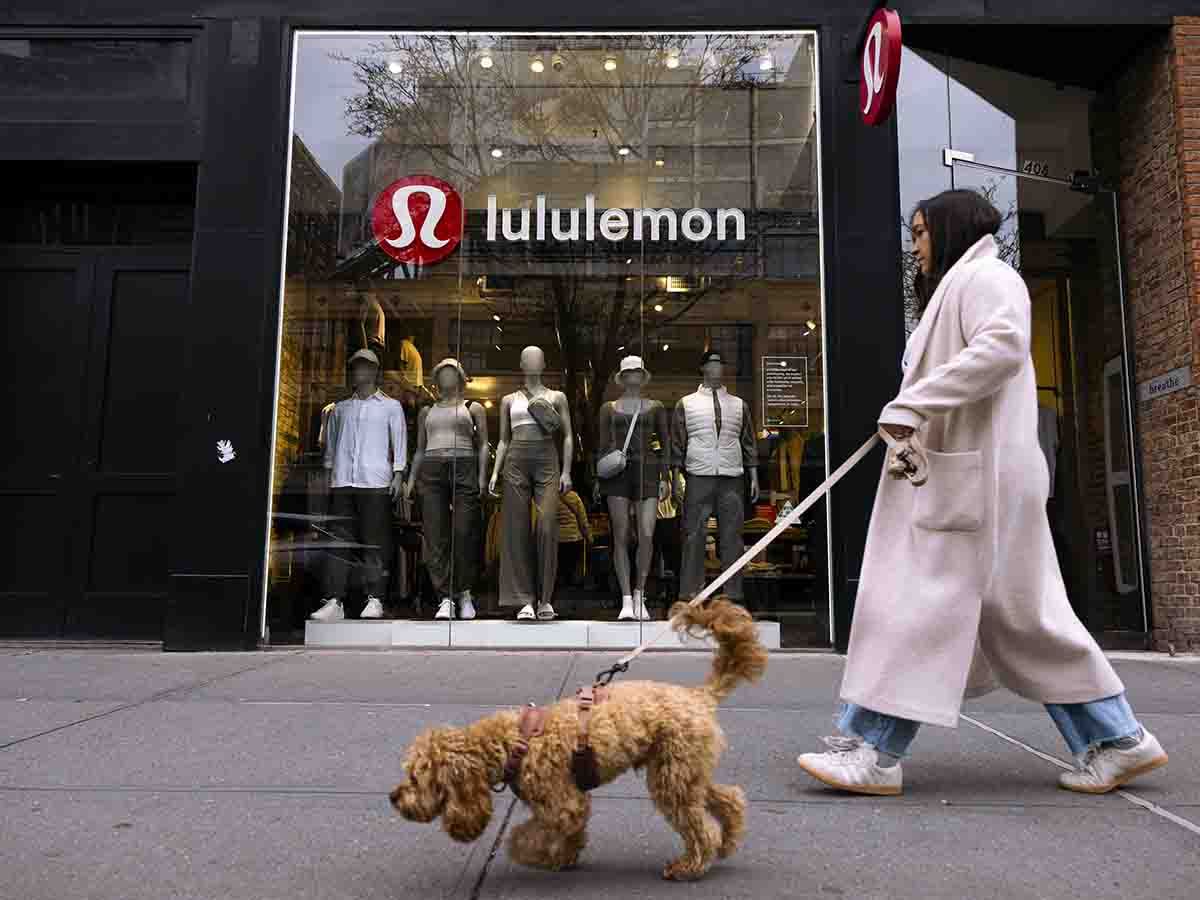 A woman walks by a Lululemon store