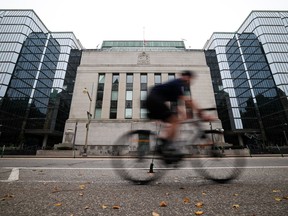 A cyclist passing in front of Bank of Canada building in Ottawa on Sept. 30, 2026.
