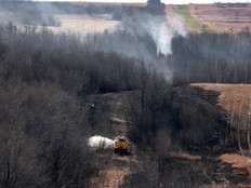 Canadian Forces fire trucks extinguish hot spots on the edge of Canadian Forces Base Wainwright on Oct. 18, 2026. Although there are oil and gas wells in the area, they were not involved in the fire.