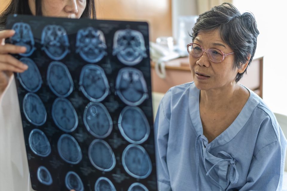 elderly woman looks at scans of her brain
