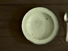 enamelled plate and spoon on wooden table