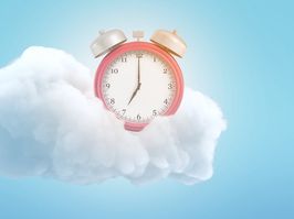 3d rendering of an old-fashioned alarm clock on a fluffy white cloud on a blue background.