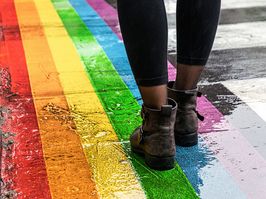 legs walking on path painted in Pride colours