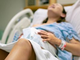 A woman in labor, with painful contractions, lying in the hospital bed. Childbirth and baby delivery.