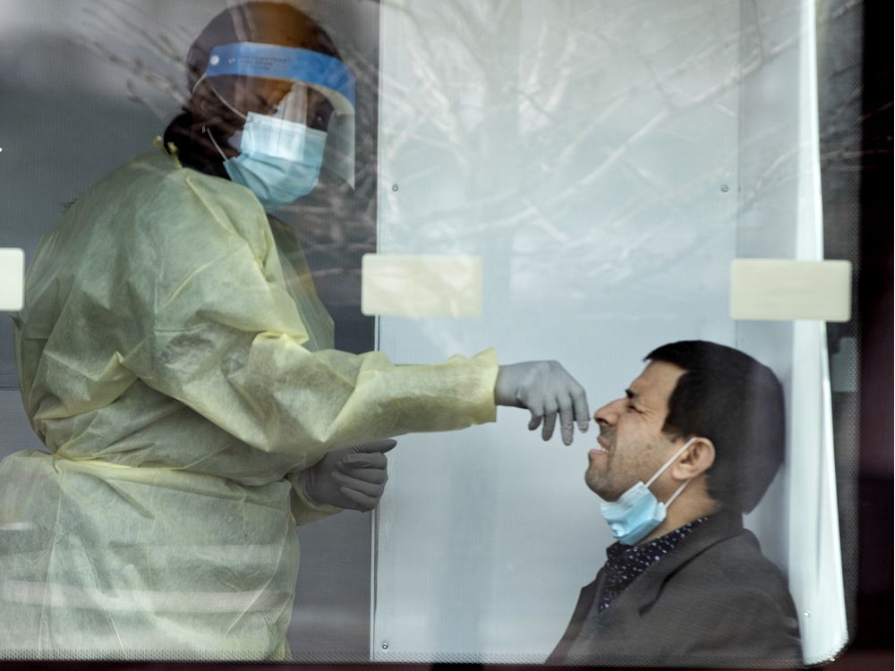 A healthcare worker administers a COVID-19 test swab at a mobile testing site in Montreal on May 9, 2020.