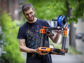 Dan Freder is seen with one of the 3D printers from St. George's High School outside his apartment in Montreal on Thursday, May 28, 2020.