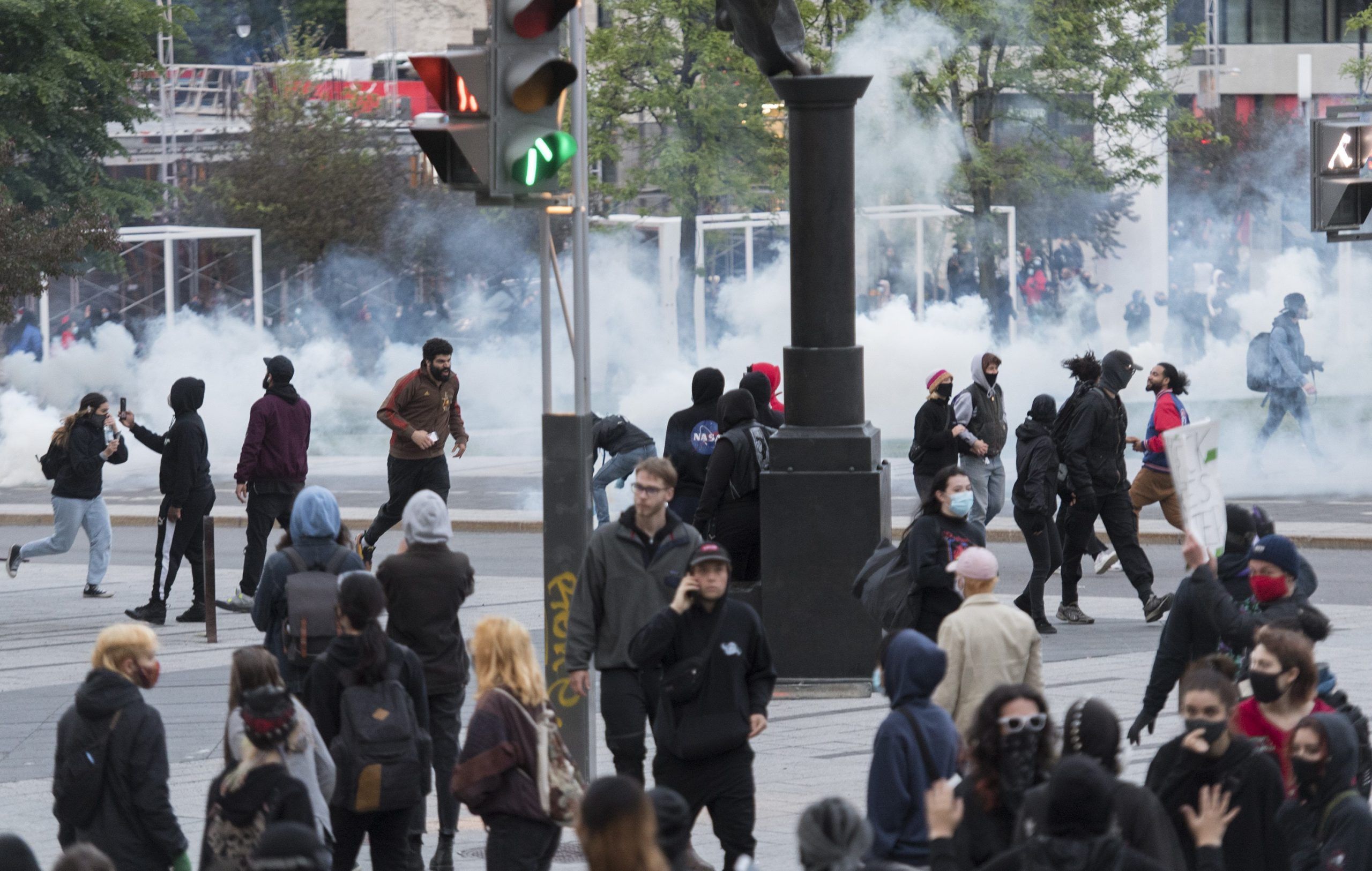 Protesters run from police during a demonstration calling for justice in the death of George Floyd and victims of police brutality in Montreal, Sunday, May 31, 2020.