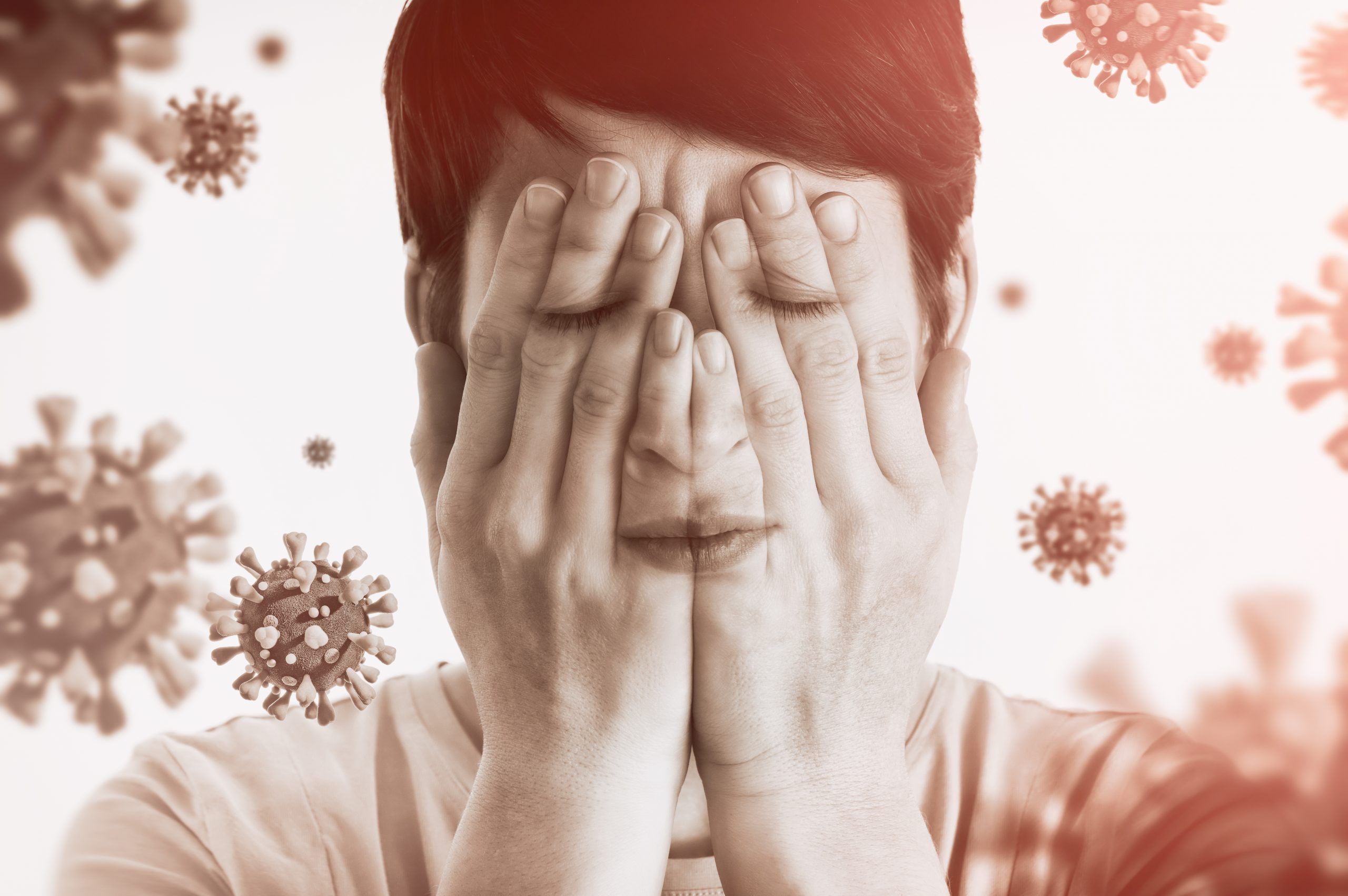 Concept of fear of coronavirus. Woman covers her face her hands on background with coronavirus.