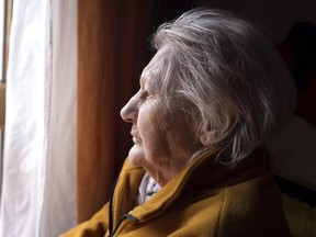 elderly woman looking out window