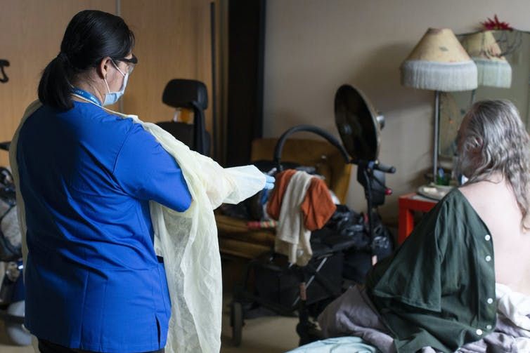 martima, a personal support worker with west neighbourhood house’s parkdale assisted living program, prepares to help a resident wash in his room at toronto’s may robinson apartments, part of tchc seniors housing, in toronto, on april 17, 2020.