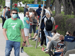 People wait in line at a COVID-19 Assessment Centre in Calgary. Contact tracing when someone tests positive has become a bit of a holy grail in the fight against COVID-19.