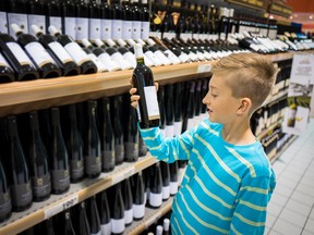 young boy in vine store buying a bottle of vine