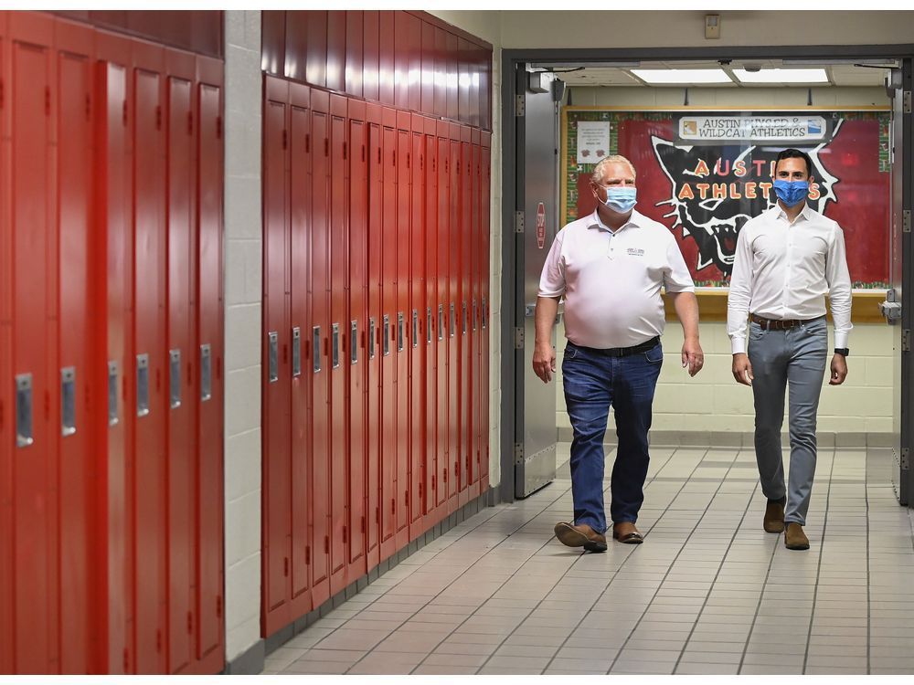 Ontario Premier Doug Ford, left, and Education Minister Stephen Lecce walk a school hallway in Whitby last week before making an announcement regarding the government's plan for a safe reopening of schools in the fall due to the COVID-19.