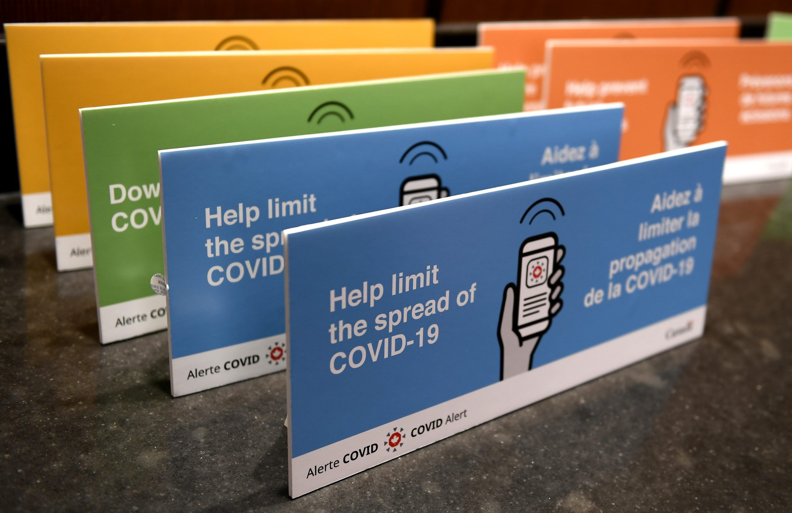 Podium placards promoting the COVID Alert app are seen on a table on Parliament Hill in Ottawa, on July 31, 2020.
