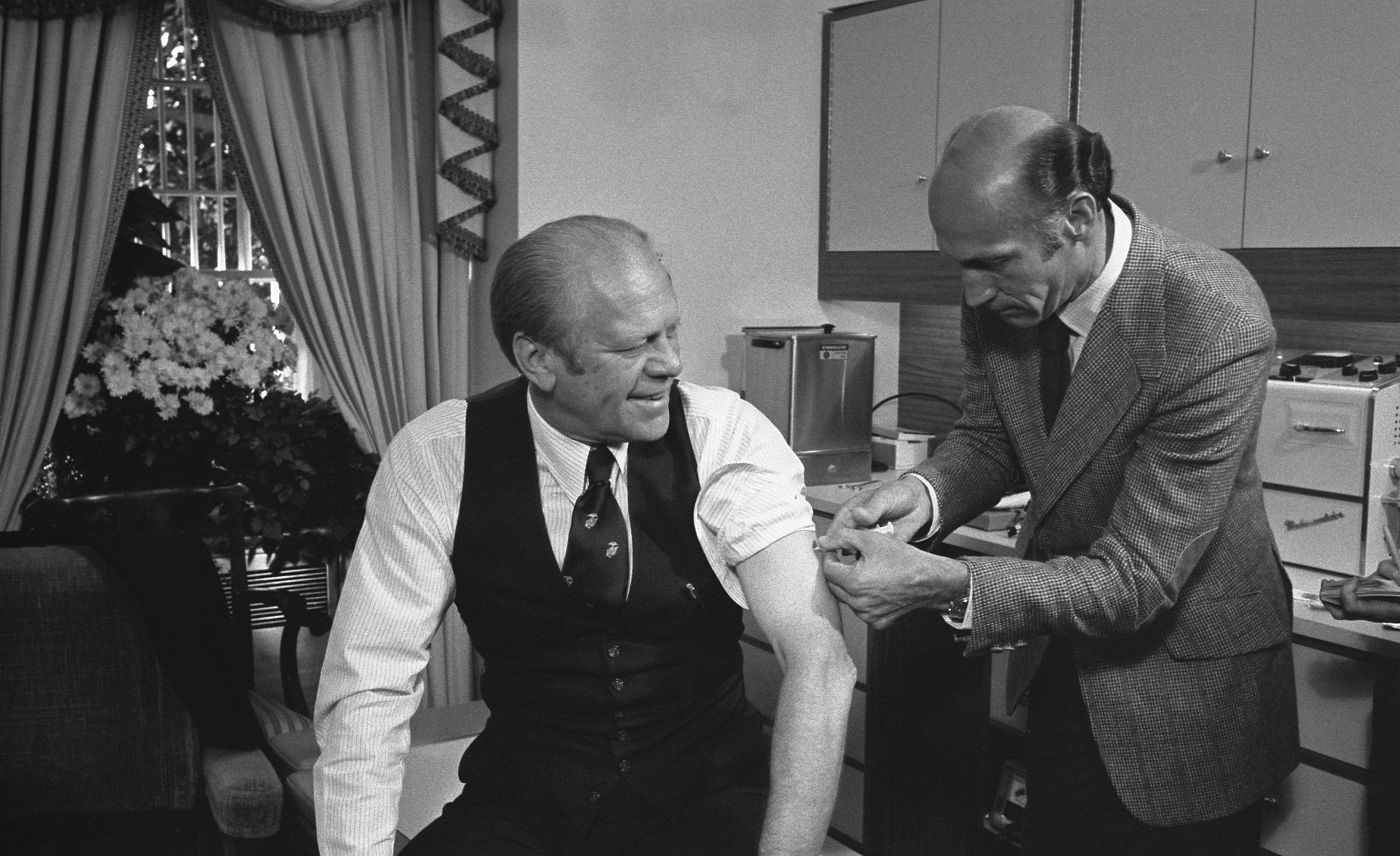 President Gerald Ford receives a swine flu innoculation from his White House physician, Dr. William Lukash.